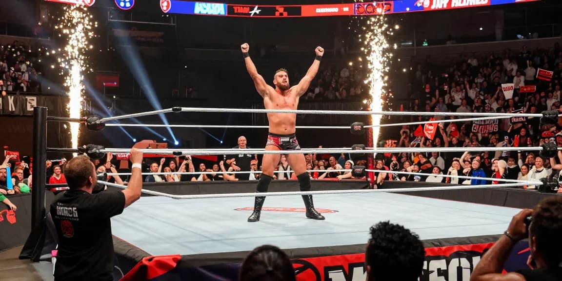 WWE MJF performing his signature pose in a packed wrestling arena during a championship match.